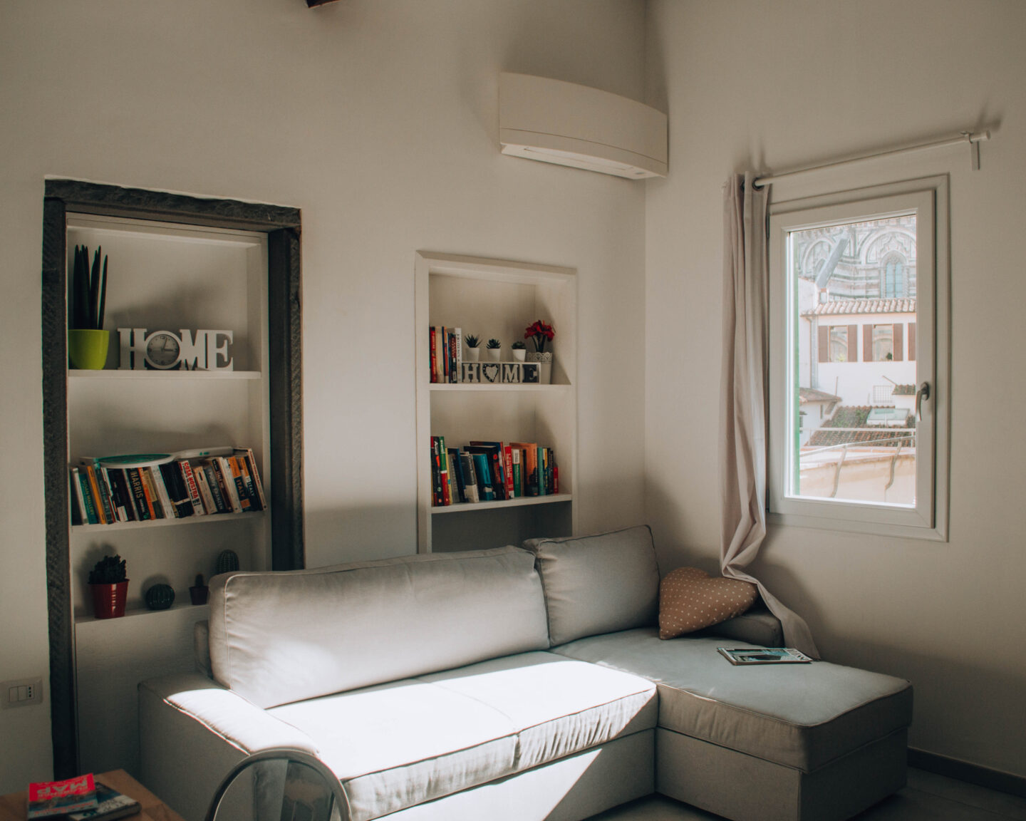 angolo living moderno con due librerie incastonate nel muro
